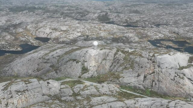 Drone shot of weather station in Norway, on top of small mountain.