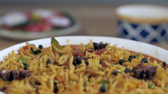 Rotating bowl full of spicy Indian vegetarian Biryani - delicious famous food. Extreme closeup shot of traditional rice dish slowly cooked with spices like star anise and black pepper