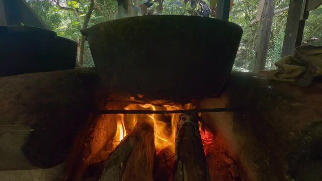 Low-angle of cauldron on burning wood for Dominican Sancocho stew preparation