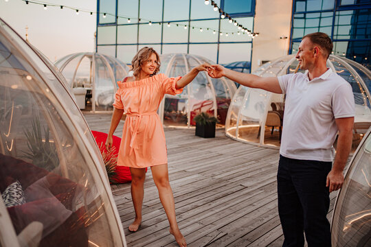 a man and a woman in love dance to a rooftop cafe on a date.