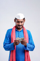 Young Indian farmer posing with currency on white background.