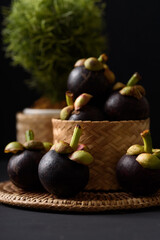 Mangosteen fruit on black background, tropical fruit mostly in Southeast Asia, refreshing and healthy eating sweet taste
