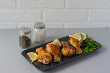 Chicken legs with spices, rosemary and lime on a gray background. Copy space.