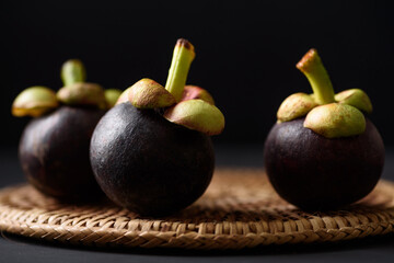 Mangosteen fruit on black background, tropical fruit mostly in Southeast Asia, refreshing and healthy eating sweet taste