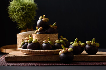 Mangosteen fruit on black background, tropical fruit mostly in Southeast Asia, refreshing and healthy eating sweet taste