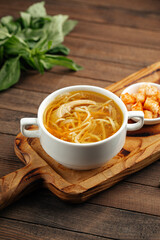 Chicken noodle soup with croutons on wooden background