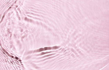 Fototapeta na wymiar Blurred or defocused transparent clear water waves in sunlight. Pink liquid colored clear water surface texture with splashes bubbles. Trendy summer exotic banner. 