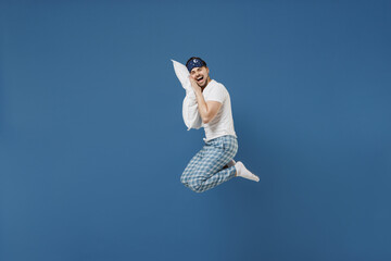 Full length side view fun young caucasian man 20s wearing pajamas jam sleep mask resting relax at...