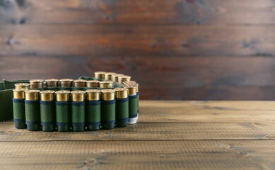 bandolier with rifle cartridges on wooden background with copy space