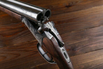 unloaded hunting rifle on a wooden background close up - obrazy, fototapety, plakaty