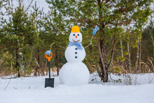 Snowman Holding Shovel Is In The Forest