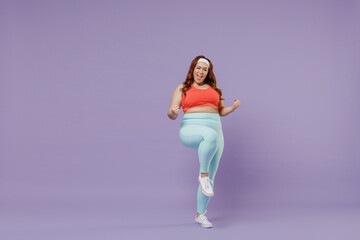 Fototapeta na wymiar Full length young chubby overweight plus size big fat fit woman wear red top warm up training do winner gesture clench fist isolated on purple background home gym. Workout sport motivation concept