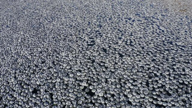 Small reflecting plates clustered together in a large water reservoir.