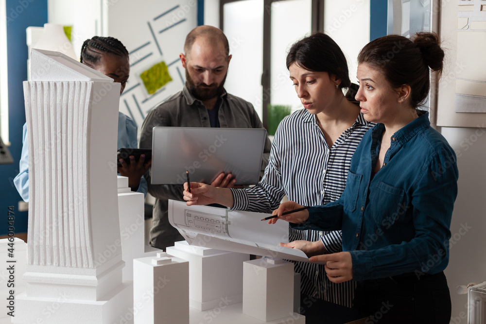 Poster architecture multi ethnic workers meeting at office analyzing blueprint plans on laptop computer tab
