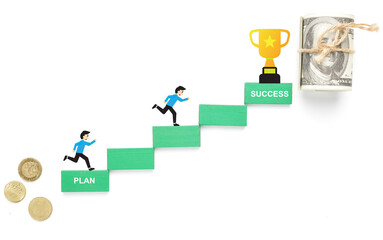 A picture of financial plan concept with illustration men running and trophy. Plan and success on green wooden block. Fake coin and money.
