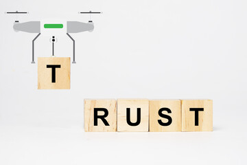 A picture of a drone carrying T word wooden block. Insight RUST wooden block. Building Trust...