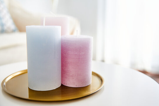 A closeup shot of purple and blue candles on the white table as a room decoration