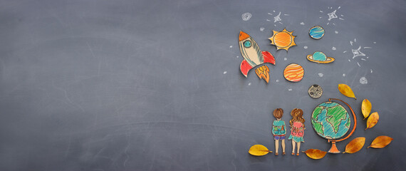 Back to school concept. Top view banner of boy and girl next to globe with autumn dry leaves over classroom blackboard background