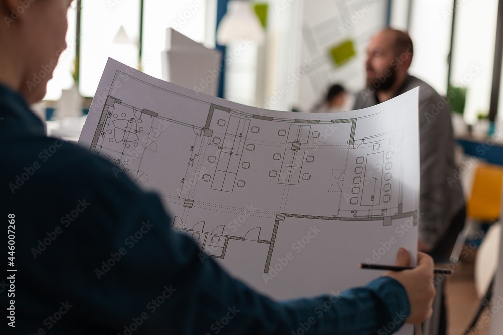 Poster architects looking at plans of blueprints for design of building model sketch layout maquette. profe