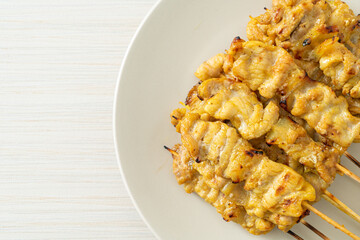 Pork satay with peanut sauce pickles which are cucumber slices and onions in vinegar