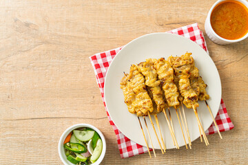 Pork satay with peanut sauce pickles which are cucumber slices and onions in vinegar