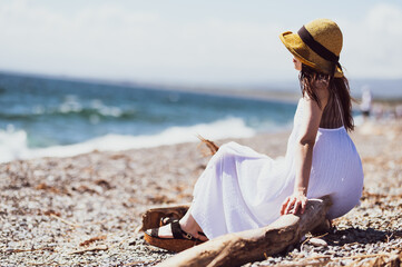 浜辺に座って遠くを見つめる女性