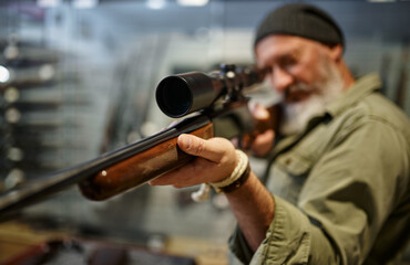 Hunter buying rifle with optical sight, gun store