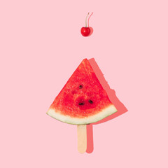 Watermelon slice as popsicle and bright red cherry pattern on pastel pink background. Creative summer idea. Summer life style concept.
