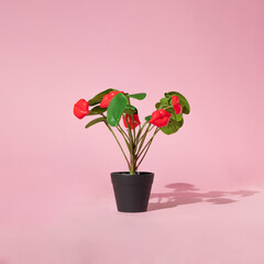Creative layout made with plant in the pot with bright red lips figurines instead of flowers on pastel pink background. 80s, 90s retro kiss love concept. Romantic aesthetic valentine's day idea.