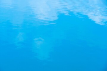 Water with ripples and cloud reflection on surface. Blank simple decorative background with space for text.