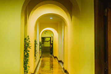 yellow hotel corridor with many classical arches and decorative vines