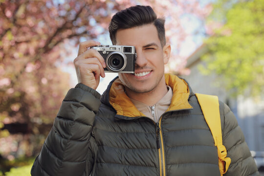 Happy male tourist with camera outdoors on spring day
