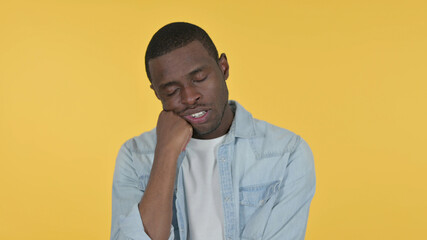 Sleepy Young African Man taking Nap, Yellow Background 