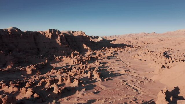 Cinematic red rocky desert, on sunny summer day with blue sky on background, 4K
