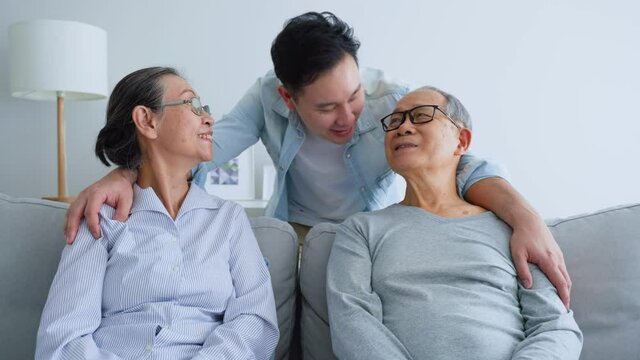 Portrait of Asian Senior old couple sit with mature son in living room