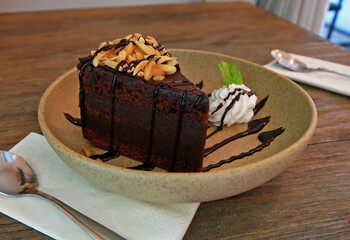 Close up Chocolate fudge brownie on topped with sliced almond in ceramic bowl