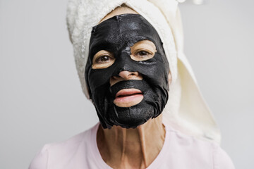 Senior woman using charcoal facial mask - Beauty skin care healthy lifestyle concept - Focus on mouth