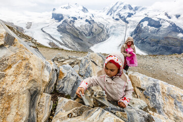 mother and daughter with backpack sitting on the footpath in the mountains at the day time.