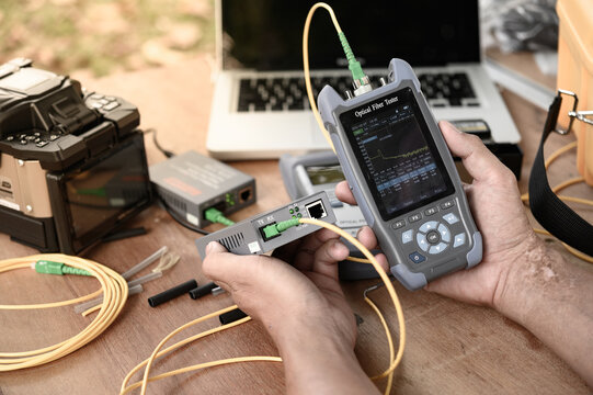 The technicians welding optical fiber cable with fusion splicing fiber optic Machine.
