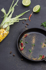 Dry red pods, ground coriander and parsley leaves in frying pan