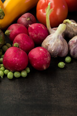 Vertical shot of fresh raw vegetables on a black wooden table