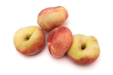 Heap of whole flat peaches isolated on white background.