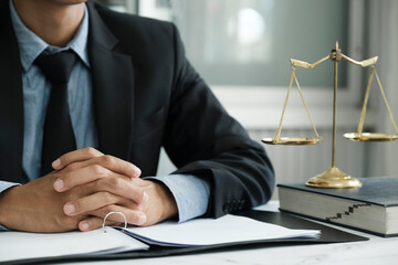 Male lawyer in the office with brass scale.