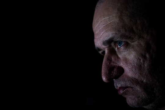 portrait of a stressed serious resilient caucasian man with black background 