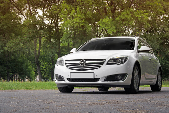 Chernihiv, Ukraine - June 16, 2018: White family car Opel Insignia in the forest on the road
