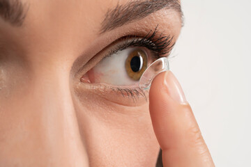  eye lens on the female finger near the eye