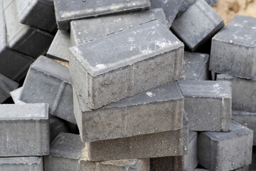 a lot of gray street bricks are standing in a pile