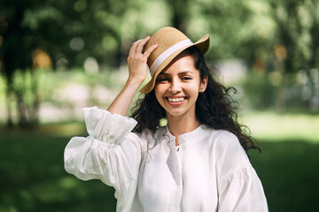 Young beautiful girl in a hat in a summer park