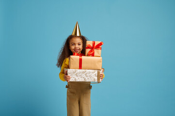 Funny little girl in cap holds birthday gift box
