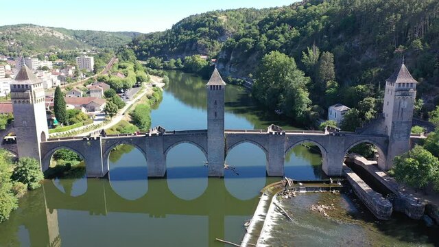Picturesque summer drone view of ancient fortified stone arch bridge Pont Valentre crossing Lot River in Cahors, Occitanie, France